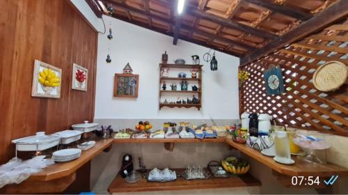 a kitchen with a counter with food on it at Pousada do Vovô Luiz in Conservatória