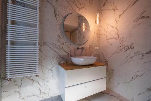 a bathroom with a sink and a mirror at PORTA VENEZIA-TRILOCALE-LUXURY con Wifi-Neflix in Milan