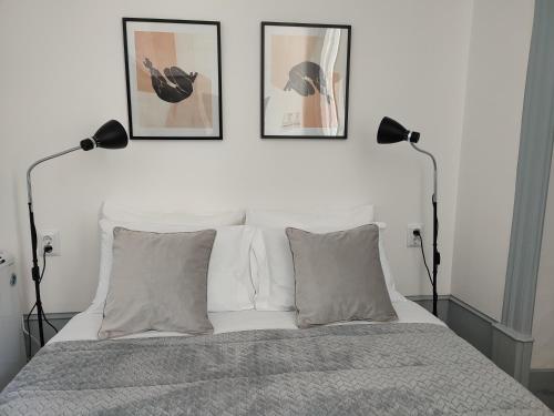 a bedroom with a bed with three pictures on the wall at Vila Santa Cruz Guest House in Braga
