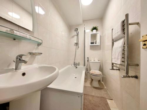 a white bathroom with a sink and a toilet at Park West Apartment in London