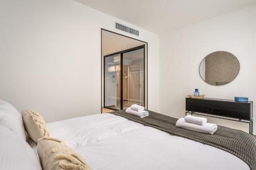 Schlafzimmer mit einem weißen Bett und einem Spiegel in der Unterkunft prestige 2BDR&2Bth w Parking- mahne yehuda sea-u jerusalem in Jerusalem