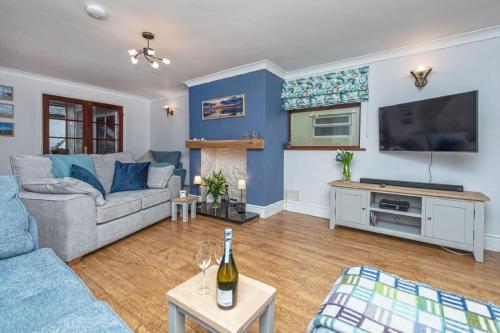 a living room with a couch and a tv at 40 Church Street in Aberffraw