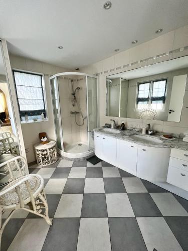 une salle de bain avec douche et sol en damier dans l'établissement Le Richelieu - Cocon familliale, à La Rochelle