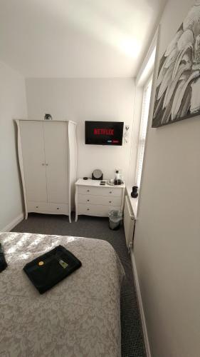 a bedroom with a bed and a dresser and a sign at The Castleton in Blackpool