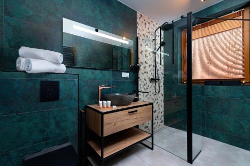 La salle de bains est pourvue d'un lavabo et d'une douche. dans l'établissement GiewontView Two-Story Apartment by Renters Prestige, à Kościelisko