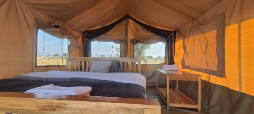a bedroom with a bed in a tent at kabwoya Safari camp Kaiso village in Kisaru