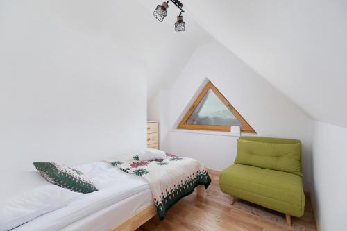 una camera con letto e sedia verde di GiewontView Two-Story Apartment by Renters Prestige a Kościelisko
