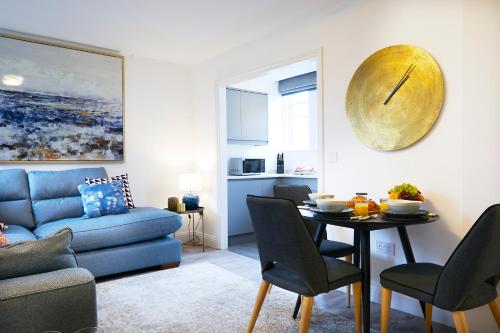 uma sala de estar com uma mesa e um sofá azul em No 3 Rosedene Muse, Marske by The Sea, modern and stylish-Yorkshire Coast Holiday Lets. em Marske-by-the-Sea