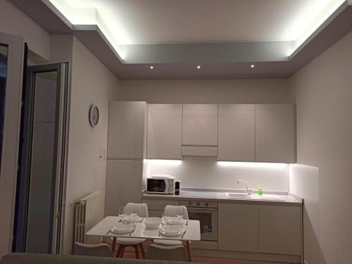 a kitchen with white cabinets and a table and chairs at Luxury House Lupetta 3 in Milan