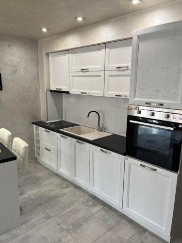 a kitchen with white cabinets and a sink at Elegant Stay in the Heart of Plovdiv Old Town in Plovdiv