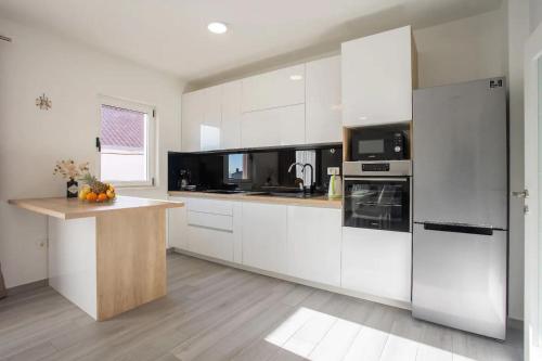eine Küche mit weißen Schränken und einer Arbeitsplatte in der Unterkunft Apartment Moon with Private Pool in Kaštela