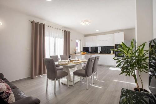 eine Küche und ein Esszimmer mit einem Tisch und Stühlen in der Unterkunft Apartment Moon with Private Pool in Kaštela