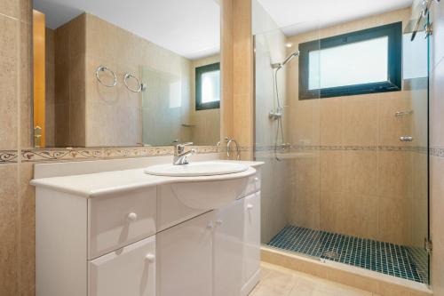 y baño blanco con lavabo y ducha. en Costa Linda 201 en Hospitalet de l'Infant