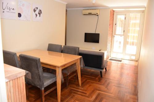 comedor con mesa de madera y sillas en Amplio Departamento 2 Dormitorios Nueva Córdoba en Córdoba