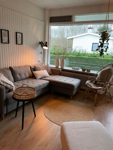 sala de estar con sofá y ventana en Appartement Dishoek No.46, en Koudekerke