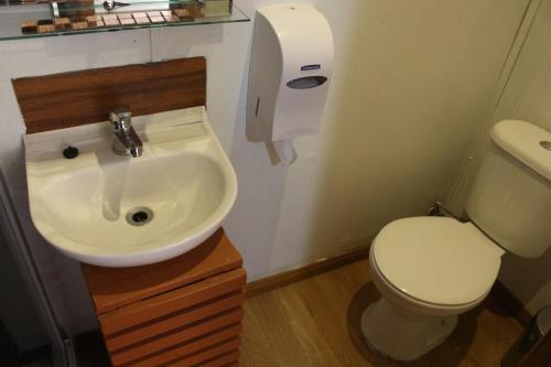 een badkamer met een wit toilet en een wastafel bij Hostal Queltehue in Ancud