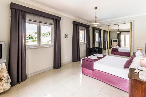 a hotel room with a bed and a tv at Villa Quinta da Marinha II in Cascais