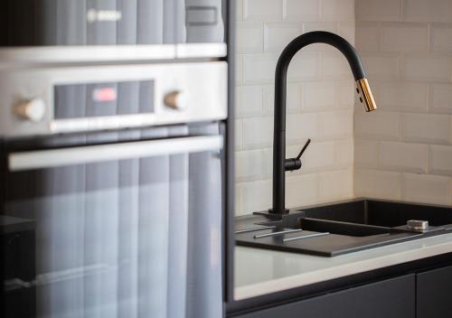 a kitchen sink with a faucet next to a refrigerator at Thyrso Village in Santo Tirso