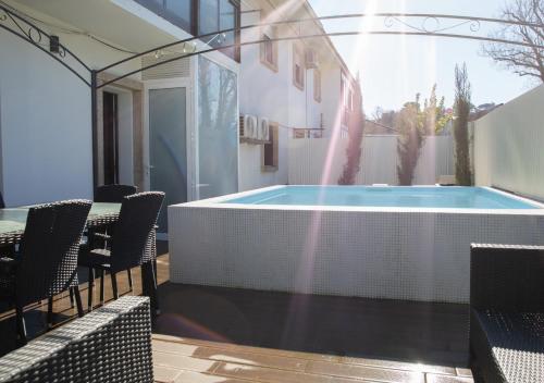 a swimming pool on a patio with a table and chairs at Thyrso Village in Santo Tirso