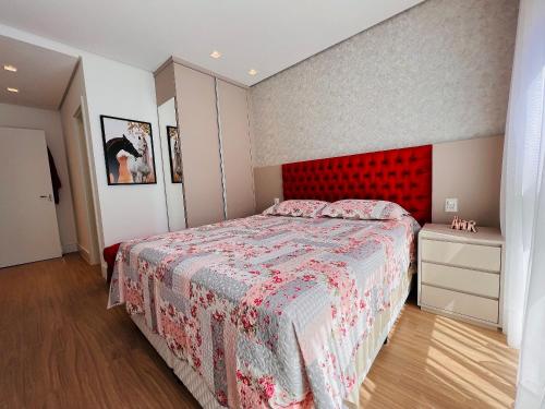 a bedroom with a bed with a red headboard at MRG - Bellagio Canela- 2 Suítes Próxima à Catedral de Pedra in Canela