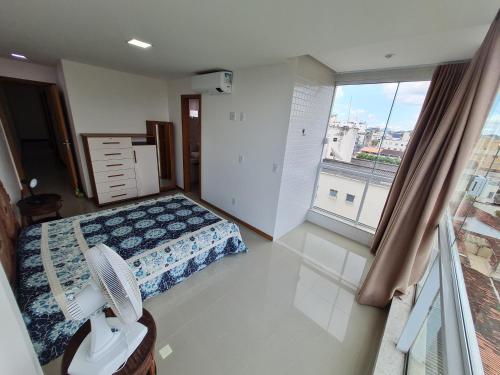 1 dormitorio con cama y ventana grande en Apt 3Q Praia do Morro a 200 m do mar 2 vgs garagem, en Guarapari