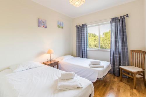 a bedroom with two beds and a window at Apartment Anibal in Aroeira