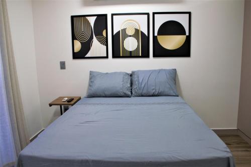 1 cama en una habitación con 4 cuadros en la pared en apartamento para até 4 pessoas, en João Pessoa