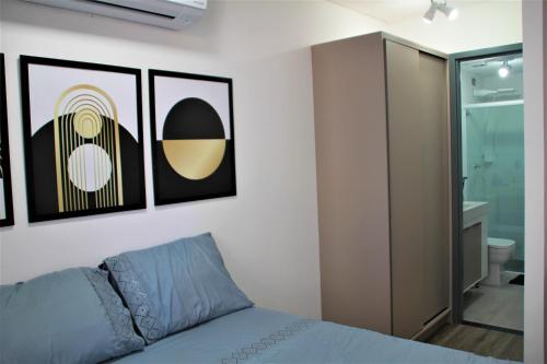 1 dormitorio con 1 cama y algunas fotos en la pared en apartamento para até 4 pessoas, en João Pessoa