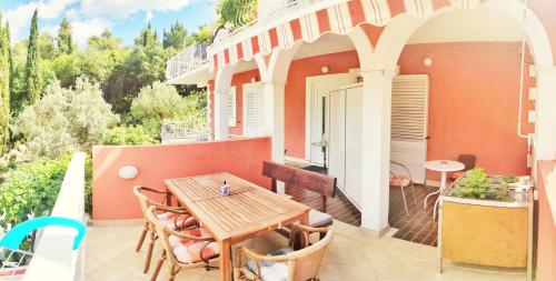 een terras met een houten tafel en stoelen bij Villa Kipre 2 in Cavtat