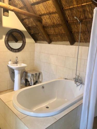 a bathroom with a bath tub and a sink at Waterberg Accommodation in Modimolle