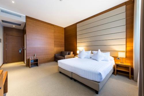 a hotel room with a bed and a chair at Occidental Aurelia in Rome