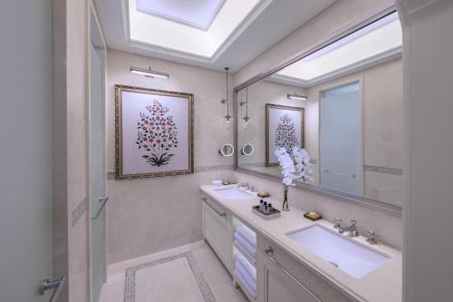 a bathroom with two sinks and a large mirror at The Chedi Katara Hotel & Resort in Doha
