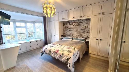 a bedroom with a bed and a brick wall at Malindi bed and breakfast in Exmouth