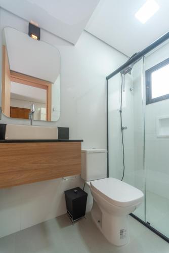 a bathroom with a toilet and a sink and a shower at Pousada Soul Papagaio - lofts completos a 30 metros do mar in Palhoça