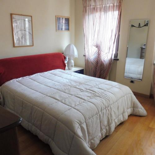 a bedroom with a large white bed and a window at Cartune' in Verzuolo