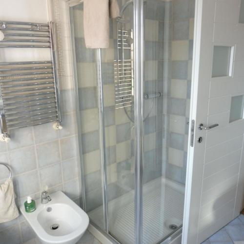 uma casa de banho com um chuveiro e um lavatório. em Cartune' em Verzuolo