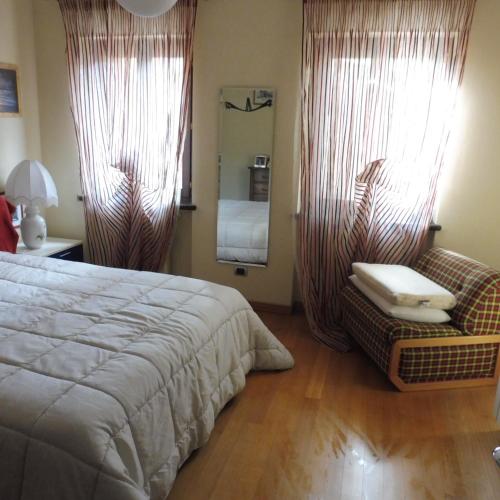 een slaapkamer met een bed, een stoel en een spiegel bij Cartune' in Verzuolo