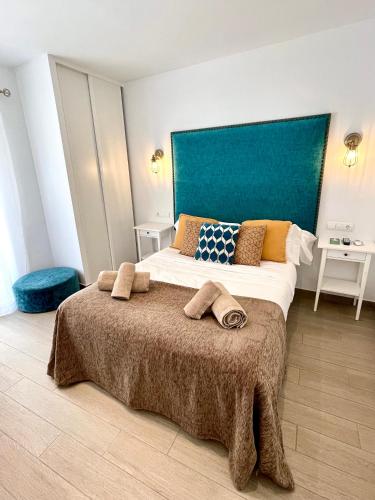 a bedroom with a large bed with towels on it at Hostal El Caprichito Marbella in Marbella