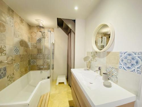 uma casa de banho com uma banheira e um lavatório e uma banheira em Sous Le Figuier em Beaumes-de-Venise