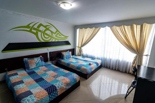 1 dormitorio con 2 camas y ventana grande en Hotel Zaclordy en Ubaté