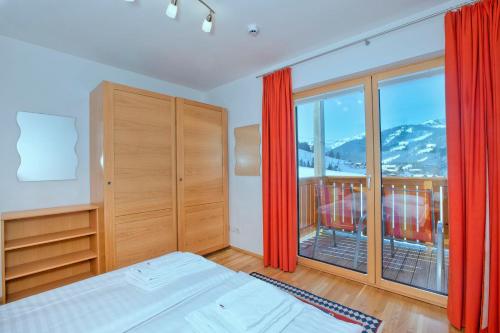 a bedroom with a bed and a large window at Mountain Resort Dienten am Hochkönig in Dienten am Hochkönig