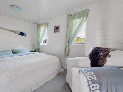 a bedroom with two beds and a couch and a window at 6 person holiday home in TORANGSVÅG-By Traum in Skår