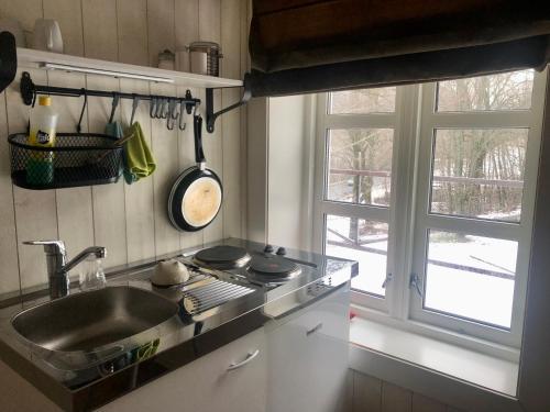 a kitchen with a sink and a stove and a window at Grønset Skysstasjon in Vinjeøra