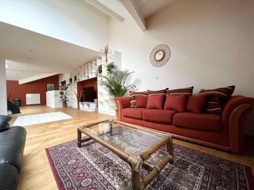 a living room with a red couch and a coffee table at Le Triplex Terracotta in Nantes