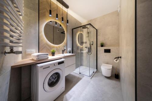 La salle de bains est pourvue d'un lave-linge et d'une douche. dans l'établissement ResiNest Apartamenty Kopernik, à Białystok