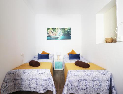 two beds in a room with white walls and blue pillows at Casa Nayroa by Spainsunrentals 1019 in Nerja