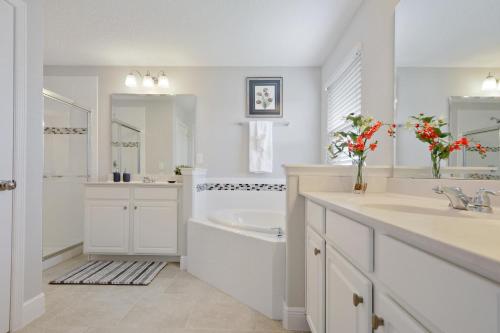 a white bathroom with a tub and a sink and a bath tub at Serene Bliss at White Rose Villas in Davenport