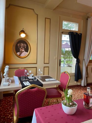 a restaurant with a table and chairs and a picture of a dog at Les 3 rois by YY in Villers-Bocage