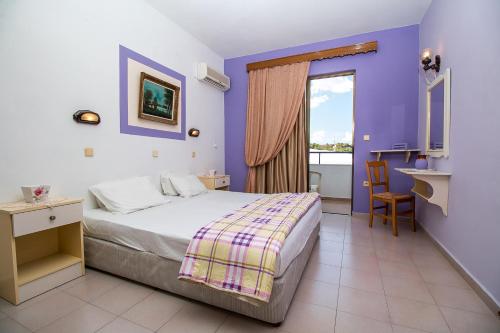um quarto de hotel com uma cama e uma janela em Ano Kampos Hotel em Faliraki