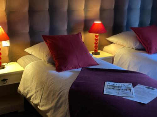 a hotel room with two beds and two lamps at Les 3 rois by YY in Villers-Bocage